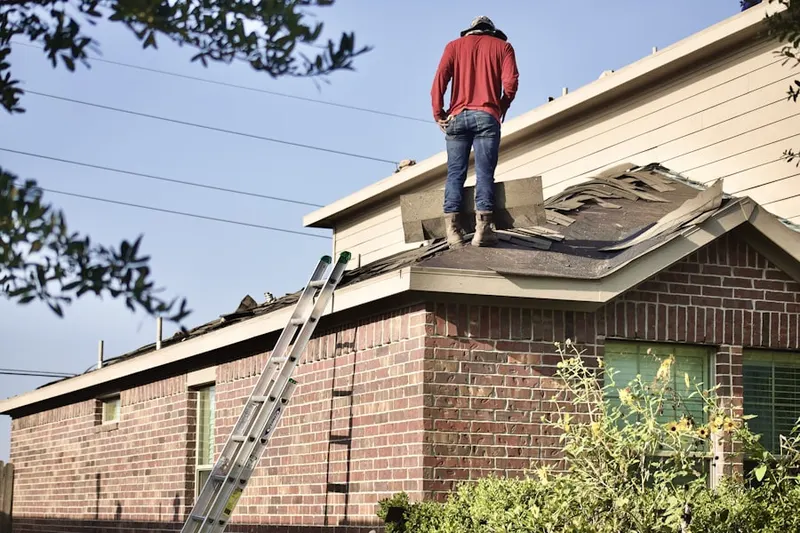 Professional roofer working on a residential roof in Ballardvale